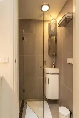 a bathroom with a toilet and a glass shower at Luxury Flower Market Apartment in Amsterdam
