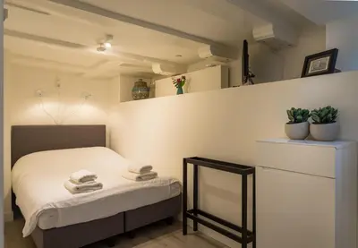 a small bedroom with a bed and a mirror at Luxury Flower Market Apartment in Amsterdam