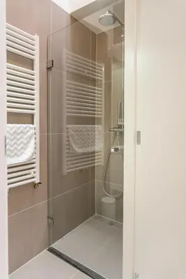 a bathroom with a shower with a glass door at Luxury Flower Market Apartment in Amsterdam