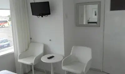 a room with two chairs and a table and a mirror at Pension 't hofje 350 meter van het strand in Noordwijk aan Zee
