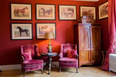 a room with two chairs and pictures of horses on the wall at Logement aan de Vecht in Breukelen