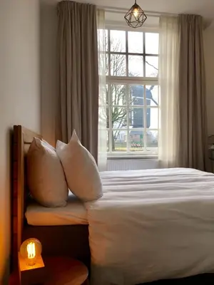 a bedroom with a bed with pillows and a window at Boutique Hotel d'Oude Morsch in Leiden