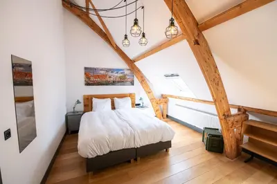 a bedroom with a large bed and a piano at Boutique Hotel d'Oude Morsch in Leiden