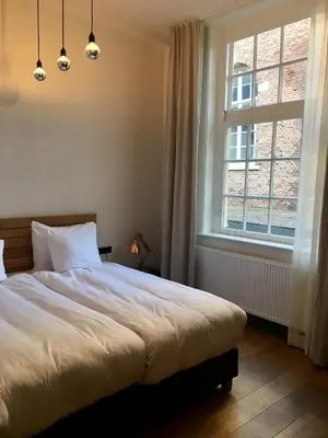 a bedroom with a large bed and a window at Boutique Hotel d'Oude Morsch in Leiden