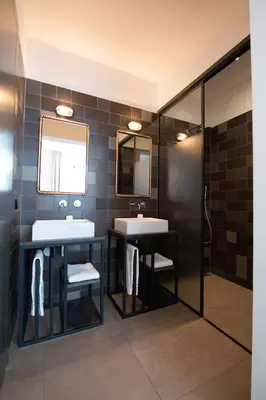 a bathroom with two sinks and two mirrors at Boutique Hotel d'Oude Morsch in Leiden