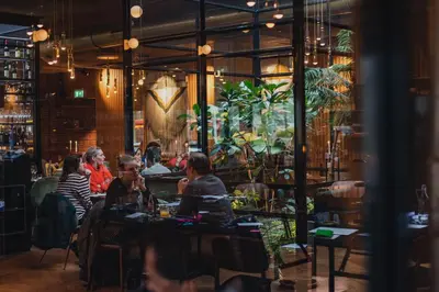 a group of people sitting at tables in a restaurant at Hotel V Fizeaustraat in Amsterdam