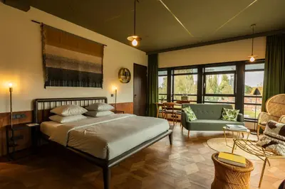a bedroom with a bed and a living room at Hotel V Fizeaustraat in Amsterdam