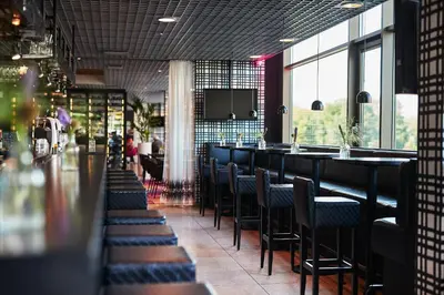 a bar in a restaurant with chairs and tables at WestCord Fashion Hotel Amsterdam in Amsterdam