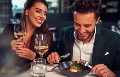 a man and woman sitting at a table with a bowl of food at WestCord Fashion Hotel Amsterdam in Amsterdam
