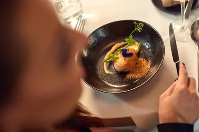 a woman sitting at a table with a plate of food at WestCord Fashion Hotel Amsterdam in Amsterdam