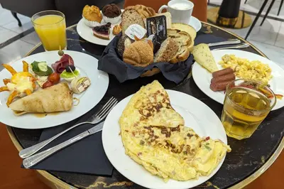 a table topped with plates of breakfast foods and drinks at Camp-Inn Hotel in Amsterdam