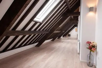 a hallway with wooden beams and a vase of flowers at Ruyge Weyde Logies, Eco Farm in Oudewater