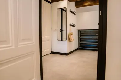 a hallway with white walls and a door with a mirror at Ruyge Weyde Logies, Eco Farm in Oudewater