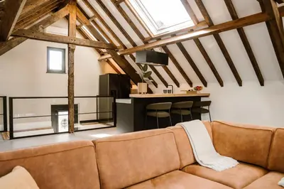 a living room with a couch and a bar at Ruyge Weyde Logies, Eco Farm in Oudewater
