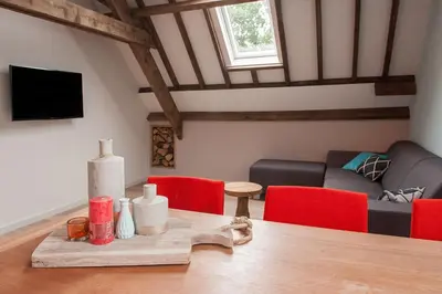 a living room with a table and a couch at Ruyge Weyde Logies, Eco Farm in Oudewater