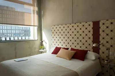 a bedroom with a large bed with red pillows at Eric Vökel Boutique Apartments - Amsterdam Suites in Amsterdam