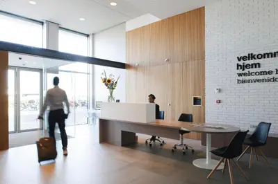 a man walking through an office with a desk at Eric Vökel Boutique Apartments - Amsterdam Suites in Amsterdam