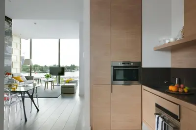 a kitchen with wooden cabinets and a dining room at Eric Vökel Boutique Apartments - Amsterdam Suites in Amsterdam