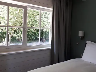 a bedroom with a bed looking out a window at Lodges near the Rhine - Sustainable Residence in Hazerswoude-Rijndijk