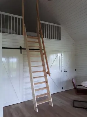 a ladder leading up to a loft bed in a room at Lodges near the Rhine - Sustainable Residence in Hazerswoude-Rijndijk