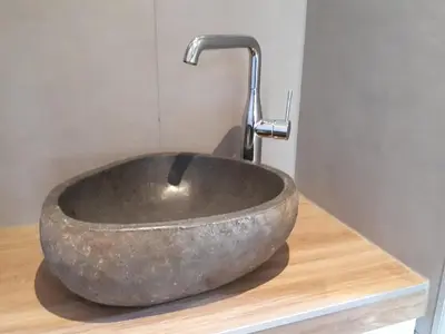 a stone sink with a faucet in a bathroom at Lodges near the Rhine - Sustainable Residence in Hazerswoude-Rijndijk
