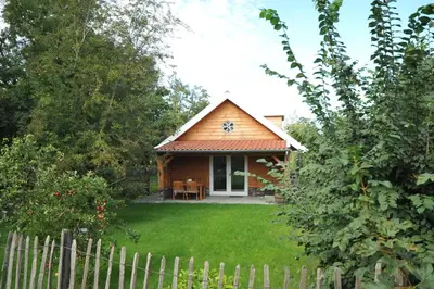 a small house with a fence in front of it at Lodges near the Rhine - Sustainable Residence in Hazerswoude-Rijndijk