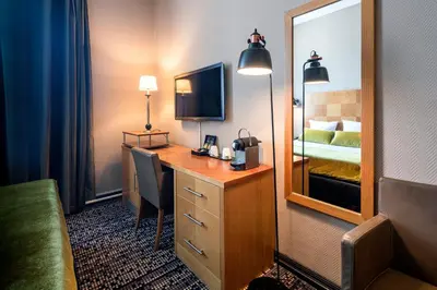 a hotel room with a desk and a mirror at The Alfred Hotel in Amsterdam
