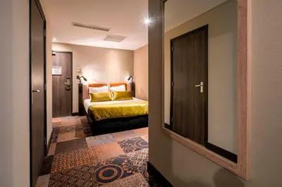 a hotel room with a bed and a mirror at The Alfred Hotel in Amsterdam