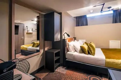 a small room with two beds and a mirror at The Alfred Hotel in Amsterdam