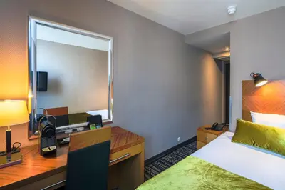 a hotel room with a bed and a mirror at The Alfred Hotel in Amsterdam