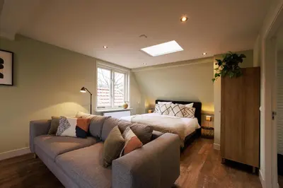 a living room with a couch and a bed at Bloemendaal Hotel Collection Apartments in Bloemendaal