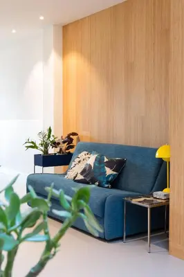 a living room with a blue couch and a table at Kith & Kin Boutique Apartments in Amsterdam
