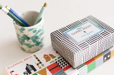 a box of stationery next to a cup of pens at Kith & Kin Boutique Apartments in Amsterdam