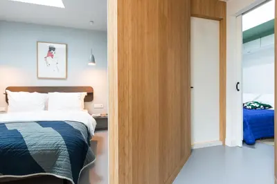 a bedroom with a bed and a sliding door at Kith & Kin Boutique Apartments in Amsterdam