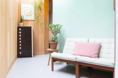 a living room with a white couch and a pink pillow at Kith & Kin Boutique Apartments in Amsterdam