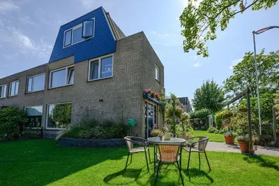 a house with a table and chairs in the yard at Bed and Breakfast Ineke en John in Hoofddorp