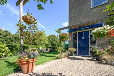 a brick walkway in front of a house with flowers at Bed and Breakfast Ineke en John in Hoofddorp