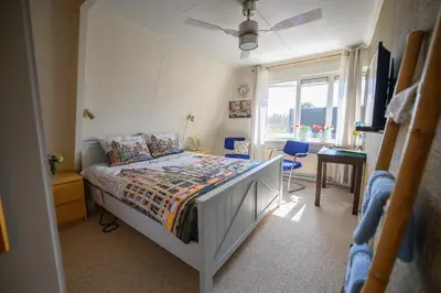 a bedroom with a bed and a desk and a window at Bed and Breakfast Ineke en John in Hoofddorp