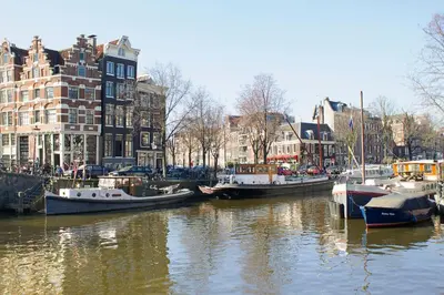 a group of boats docked in a canal with buildings at Mercedes Bed&Breakfast Amsterdam in Amsterdam