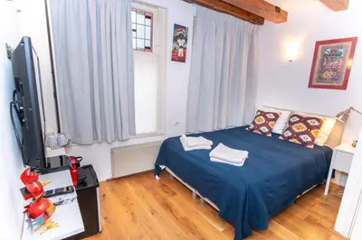a bedroom with a bed and a flat screen tv at Mercedes Bed&Breakfast Amsterdam in Amsterdam