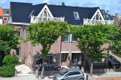 a red brick house with a car parked in front of it at Residance Anne's Beach in Zandvoort