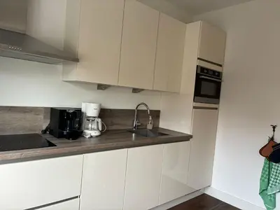 a kitchen with white cabinets and a sink at Residance Anne's Beach in Zandvoort