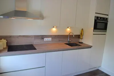 a kitchen with white cabinets and a sink at Residance Anne's Beach in Zandvoort