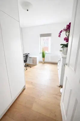 an open door to a room with white walls and wood floors at Residance Anne's Beach in Zandvoort