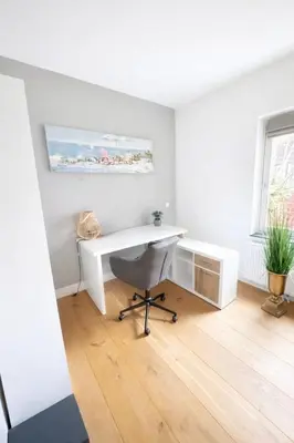 a white desk with a chair in a room at Residance Anne's Beach in Zandvoort