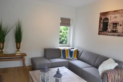 a living room with a couch and a table at Residance Anne's Beach in Zandvoort