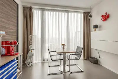 a dining room with a table and chairs in front of a window at Black Jack Suites in Amsterdam