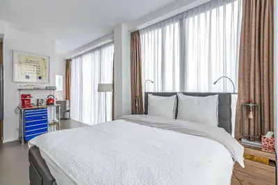 a bedroom with a large bed with white sheets at Black Jack Suites in Amsterdam