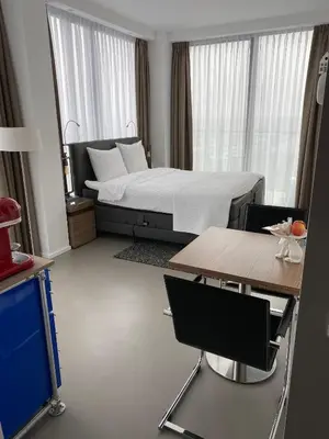 a bedroom with a bed and a table and chairs at Black Jack Suites in Amsterdam