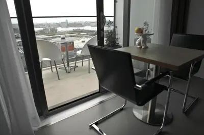 a dining room table and chair in front of a window at Black Jack Suites in Amsterdam